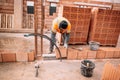 Close up portraits of mason working with bricks, mortar,