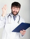 Close-up portret of a Doctor holding a map-case for note, stethoscope around his neck. He is angry and shakes his hand Royalty Free Stock Photo