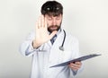 Close-up portret of a Doctor holding a map-case for note, stethoscope around his neck. He held up his hand, palm forward Royalty Free Stock Photo