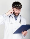 Close-up portret of a Doctor holding a map-case for note, stethoscope around his neck. He twists his index finger at his Royalty Free Stock Photo