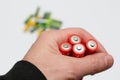 Red colours of batteries in hand on a white background. Close up of positive ends batteries, selective focus. Used battery for