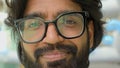 Close up positive male face in eyeglasses. Portrait Indian bearded man in glasses smiling looking at camera. Headshot