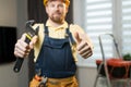 Positive handyman showing work tool Royalty Free Stock Photo