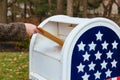 Close-up Of Postman Putting Letters Mailbox American flag Royalty Free Stock Photo