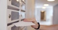 Close up of postman putting letters in mailbox in apartment house lobby Royalty Free Stock Photo