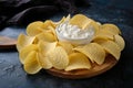 Close-up potato chips and sauce in a white bowl on a wooden cutting board Royalty Free Stock Photo