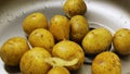 Close up. Potato peelings fall on raw potatoes in the sink