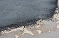 A close-up of a pothole repair on the road, repaired patched asphalt driveway. Old and new asphalt on the pavement Royalty Free Stock Photo