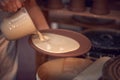 Close Up Of Potter Applying Glaze To Clay Plate In Ceramics Studio