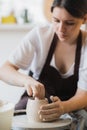 Close-up of potter making pot in pottery workshop. Using sponge and water for moisturizing clay. Royalty Free Stock Photo