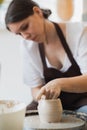 Close-up of potter making pot in pottery workshop. Using sponge and water for moisturizing clay. Royalty Free Stock Photo