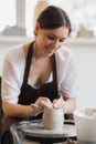 Close-up of potter making pot in pottery workshop. Using sponge and water for moisturizing clay. Royalty Free Stock Photo