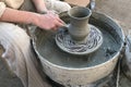 Close up of a potter master working behind a pottery wheel. Pottery, modeling of blue clay. Freshly made elegant ornamental vase