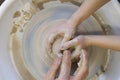 Close-up of a potter`s hands and a child`s hand with an item on a potter`s wheel. Working with clay Royalty Free Stock Photo