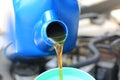 Close up of Pouring fresh oil to car engine in auto repair service, Change oil