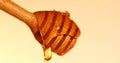 Close up a pouring golden sweet honey dripping on honey dipper