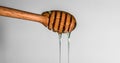 Close up a pouring golden sweet honey dripping on honey dipper