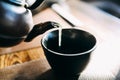 Close up pouring a hot Japanese green tea kettle on an oriental style cup on table Royalty Free Stock Photo