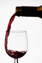 Close up of pouring of red dry wine in a crystal wine glass from full bottle of wine Royalty Free Stock Photo