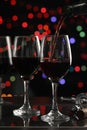 Close up pouring the red wine into the wine glass with color bokeh background in the pub bar concept Royalty Free Stock Photo