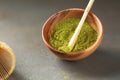 Close up powder of matcha tea is partially dissolved in hot water