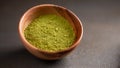 Close up powder of matcha tea is partially dissolved in hot water