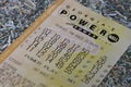 Close up of Power Ball lottery ticket on shreds of unfit currency.