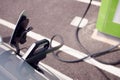 Close Up Of Power Cable Charging Electric Car Outdoors In Supermarket Car Park