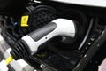 Close up of power supply plugged into an electric car being charged Royalty Free Stock Photo