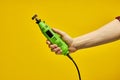 close-up Power tool. Green Die grinder in hands  on yellow background Royalty Free Stock Photo