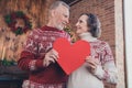 Close-up pphoto portrait couple celebrating winter holidays together keeping red heart postcard