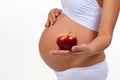 Close-up of pregnant belly and apple. Vitamins and healthy food during pregnancy