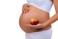 Close-up of pregnant belly and apple. Vitamins and healthy food during pregnancy