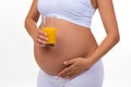 Close-up of a pregnant belly and glass of fresh orange juice Royalty Free Stock Photo