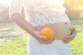 Close up pregnant belly holding oranges in hand