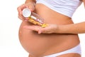 Close-up of pregnant belly with prenatal vitamins. Tablets, pills during pregnancy Royalty Free Stock Photo