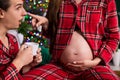 Close-up on the pregnant belly of a woman touching her husband& x27;s nose with her finger. Royalty Free Stock Photo