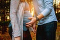 Close up of pregnant couple with hands on belly