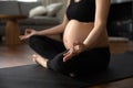 Close up pregnant woman in black sportswear practicing yoga, meditating Royalty Free Stock Photo