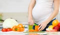 Close up pregnant woman cuts vegetables Royalty Free Stock Photo