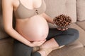 Close up of pregnant woman enjoys eating crunchy chocolate cereal balls from a bowl relaxing on the sofa. Dieting during pregnancy Royalty Free Stock Photo