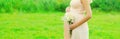 Close up of pregnant woman with flowers in sunny summer day Royalty Free Stock Photo