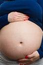 Close-up of pregnant woman grabbing belly