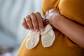 Pregnant woman holding baby socks on belly Royalty Free Stock Photo