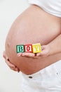 Close Up Of Pregnant Woman Holding Blocks Spelling BOY