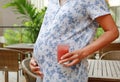 Close-up pregnant woman holding glass of strawberry juice at the restaurant on the morning. Nutrition and diet during pregnancy Royalty Free Stock Photo