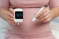 Pregnant woman holding glucose meter with result of measurement sugar high level. gestational diabetes concept