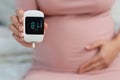 Pregnant woman holding glucose meter with result of measurement sugar level. gestational diabetes concept