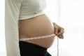 Close up pregnant woman measuring her belly Royalty Free Stock Photo