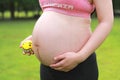 Close-up of pregnant woman mother belly, hold yellow toy smile emoji keep healthy positive attitude